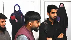 Mahasiswa laki-laki berdiri di depan poster yang memerintahkan perempuan untuk menutupi diri mereka dengan Jilbab, di koridor sebuah universitas swasta setelah universitas dibuka kembali di Kabul, Afghanistan, Senin (6/3/2023). Universitas di Afganistan kembali dibuka setelah sempat diliburkan selama musim dingin. (Wakil KOHSAR / AFP)