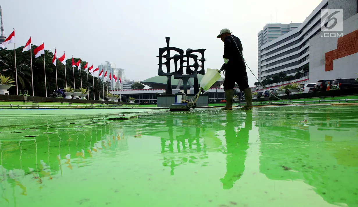 Pekerja membersihkan kolam di kompleks Parlemen, Senayan, Jakarta, Senin (31/7). Bersih - bersih ini dilakukan tiga bulan sekali untuk perawatan Gedung MPR/DPR/DPD. (Liputan6.com/Johan Tallo)
