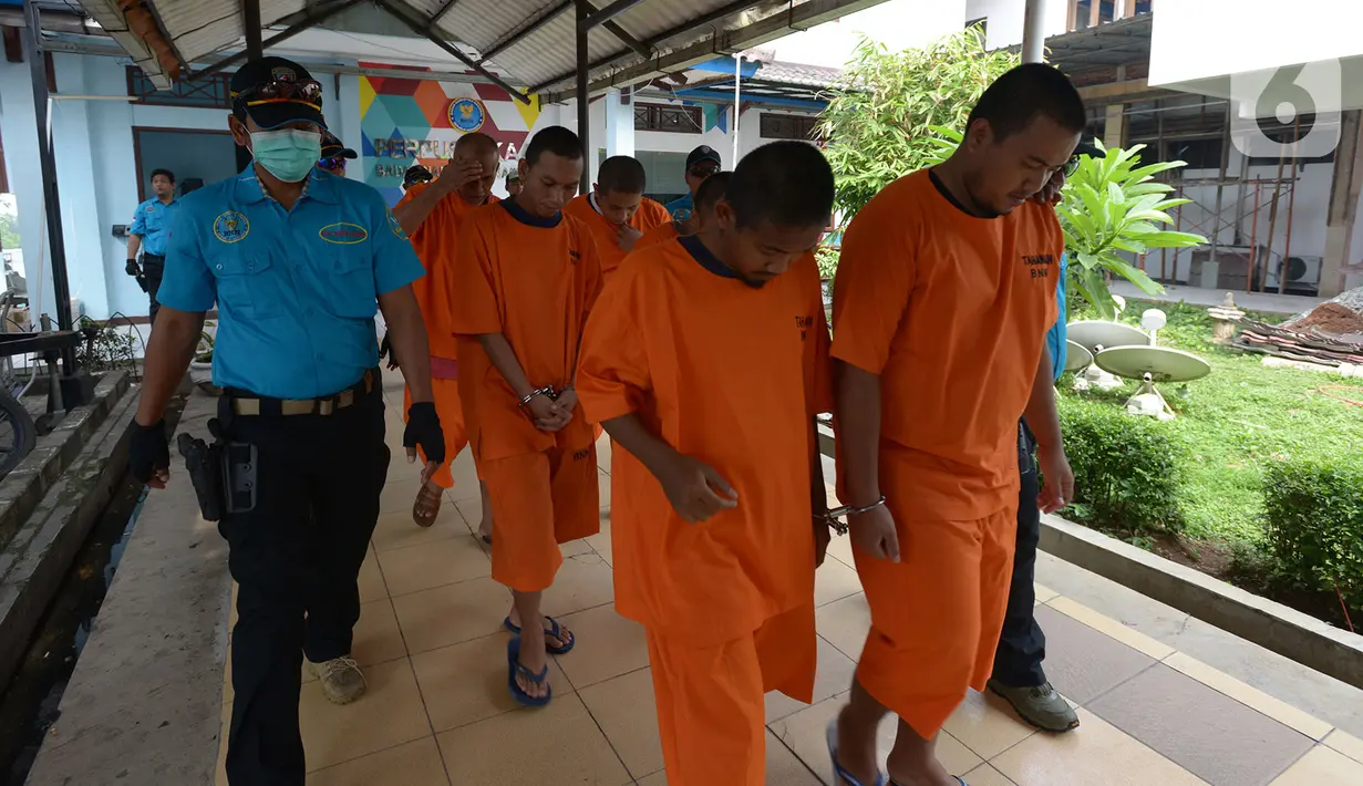 Para tersangka mengikuti pemusnahan barang bukti narkotika di Lapangan Parkir Badan Narkotika Nasional (BNN), Jakarta, Jumat (20/12/2019). Barang bukti narkoba ini didapatkan BNN dari penggerebekan pabrik hingga cara penyeludupan dari Prancis ke Indonesia. (merdeka.com/Imam Buhori)