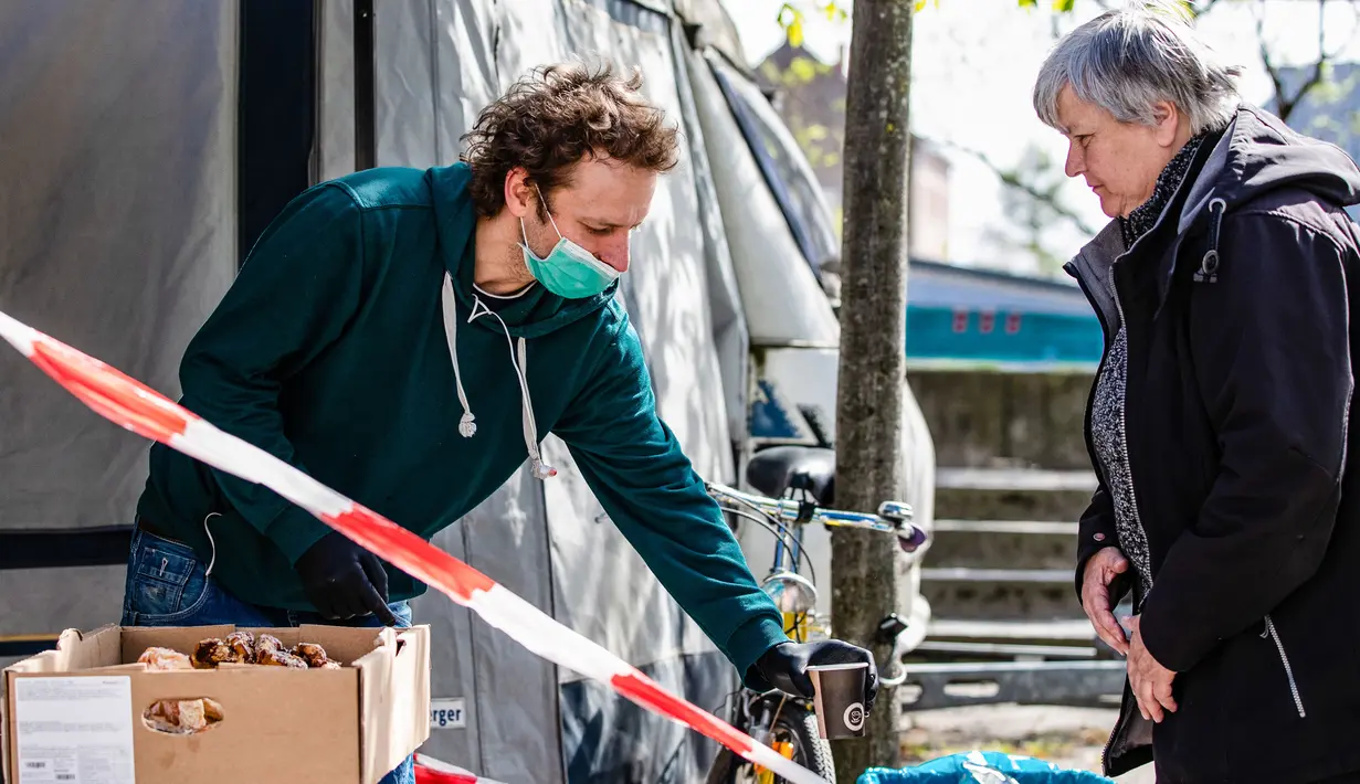 Seorang staf perusahaan katering (kiri) menyiapkan makanan gratis untuk warga lanjut usia di Berlin, Jerman (16/4/2020). Tingkat infeksi baru COVID-19 di Jerman terus berada di bawah masa puncak saat jumlah kasus terkonfirmasi bertambah 2.866 dalam satu hari menjadi 130.450. (Xinhua/Binh Truong)