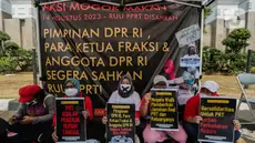 Sejumlah anggota aliansi Mogok Makan Untuk Undang Undang Perlindungan Pekerja Rumah Tangga (UU PPRT) membentangkan poster saat aksi di depan Gedung DPR, Jakarta, Senin (14/8/2023). (Liputan6.com/Faizal Fanani)