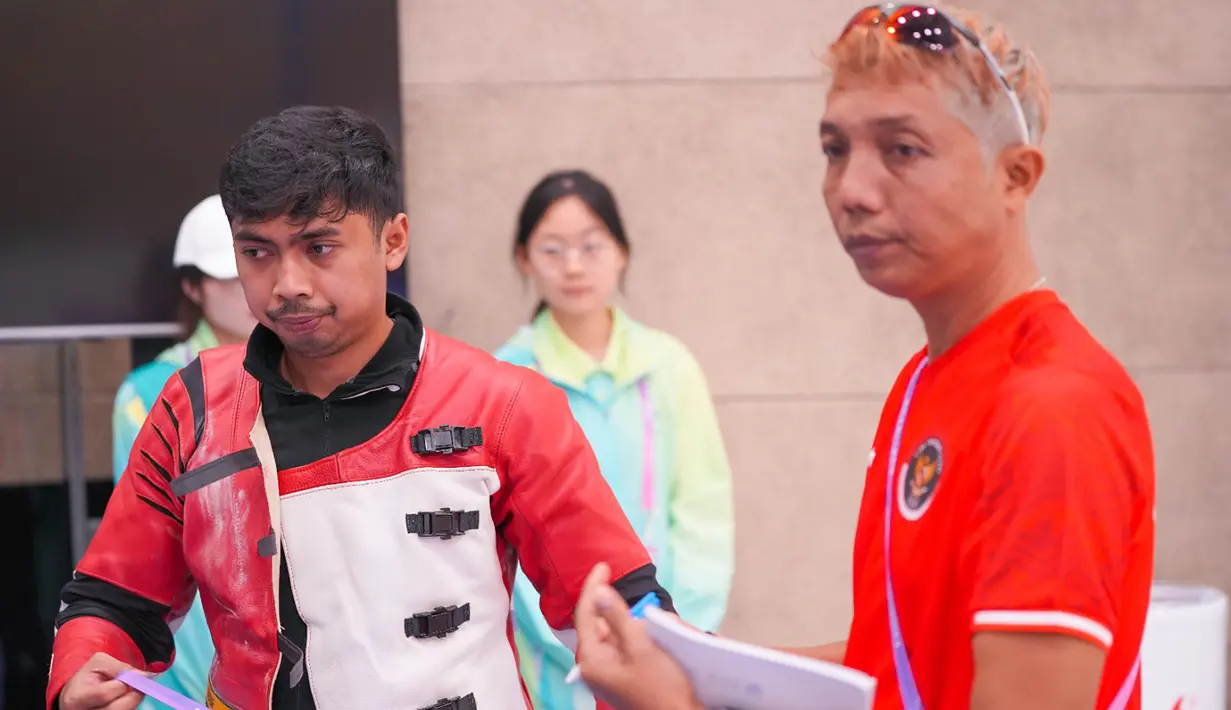 Petembak Indonesia, Muhammad Sejahtera Dwi Putra didampingi ofisial tim saat berlomba di nomor perorangan 10 meter running target putra cabang menembak Asian Games Hangzhou 2022 di Fuyang Yinhu Sports Centre, Hangzhou, China, Senin (25/9/2023). (NOC Indonesia)