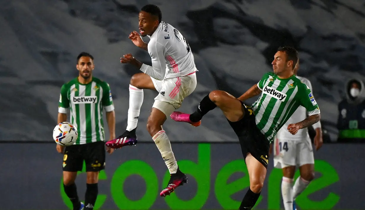 Bek Real Madrid, Eder Militao (tengah) berebut bola dengan striker Real Betis, Loren Moron dalam laga lanjutan Liga Spanyol 2020/2021 pekan ke-33 di Alfredo Di Stefano Stadium, Madrid, Sabtu (24/4/2021). Real Madrid bermain imbang 0-0 dengan Real Betis. (AFP/Gabriel Bouys)