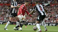 Penyerang Manchester United, Cristiano Ronaldo menggiring bola dari kawalan pemain Newcastle United, Sean Longstaff dan Jamaal Lascelles pada pertandingan Liga Inggris di stadion Old Trafford, Sabtu (11/9/2021). Ronaldo mencetak dua gol dan mengantar MU menang 4-1. (AP Photo/Rui Vieira)