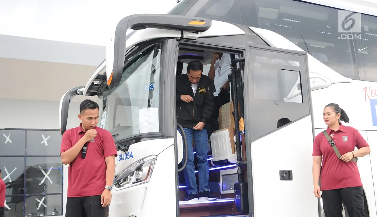 Presiden Joko Widodo turun dari bus usai menjajal jalan Tol Trans Jawa, Kamis (20/12). Jokowi menggunakan bus melakukan uji coba trans Jawa sepanjang 341 km dari Surabaya menuju Jembatan Kali Kuto, di Kendal, Jawa Tengah. (Liputan6.com/Angga Yuniar)