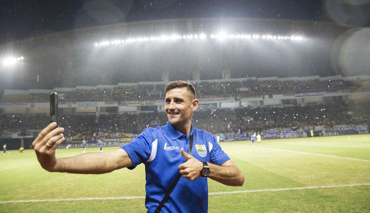 Striker anyar Persib Bandung, Juan Belencoso, tampak takjub dengan kemeriahan pendukung Maung Bandung atau Bobotoh di Stadion Wibawa Mukti, Bekasi. Dirinya aksi selfie dengan latar belakang Bobotoh. (Bola.com/Vitalis Yogi Trisna)