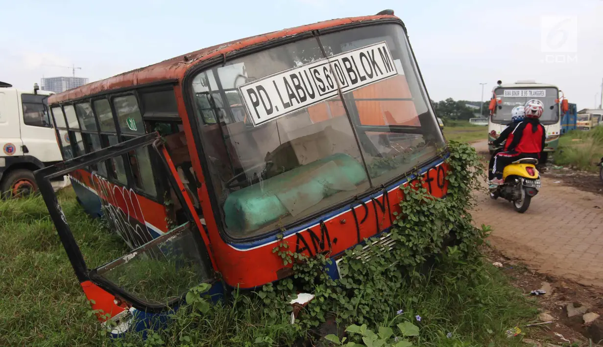 Pengendara motor melintas disamping bus Metromini di Pool Bus Dinas Perhubungan DKI Jakarta, Rawa Buaya, Jumat (23/3). Bus Metromini yang rusak dan tak layak mulai digantikan oleh angkutan umum Minitrans dan Metrotrans. (Liputan6.com/Arya Manggala)