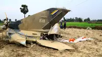 Reruntuhan jet tempur milik Myanmar jatuh di area persawahan desa Kyunkone yang berjarak satu jam dari ibu kota Naypyidaw, Selasa (3/4). Pilot pesawat jet tempur tersebut tewas karena lukanya saat dalam perjalanan ke rumah sakit militer. (AFP Photo)