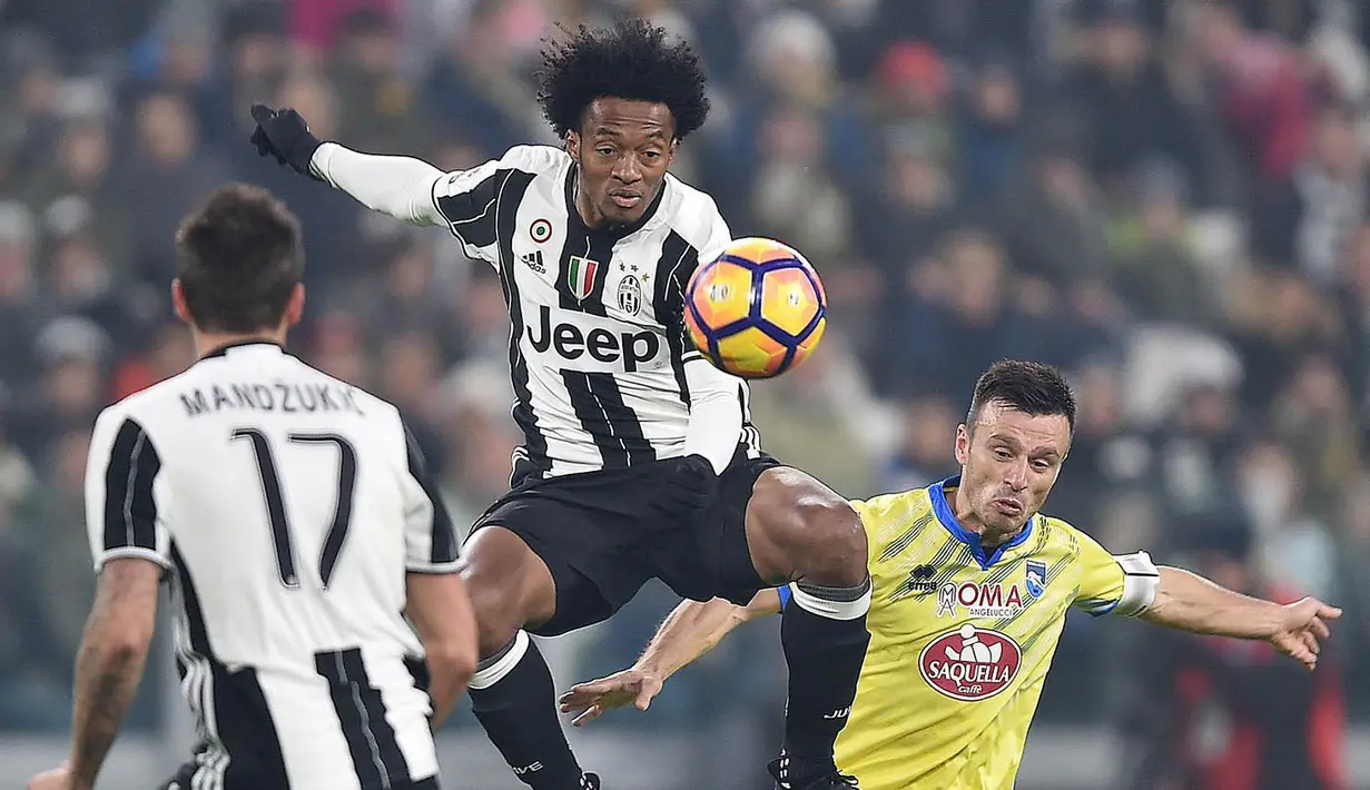 Gelandang Juventus, Juan Cuadrado, berusaha membuang bola dari pemain Pescara, Ledian Memushaj. Kekalahan ini membuat Pescara kian terpuruk di zona degradasi. (EPA/Alessandro Di Marco)