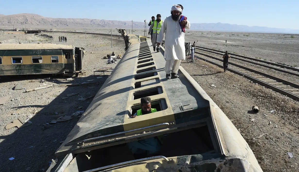Tim penyelamat memeriksa gerbong kereta api yang tergelincir dari rel di daerah pegunungan Bolan dekat Quetta dalam perjalanan ke Rawalpindi, Pakistan, Selasa (17/11). Sedikitnya 12 orang tewas dalam kecelakaan tersebut. (AFP PHOTO/BANARAS KHAN)