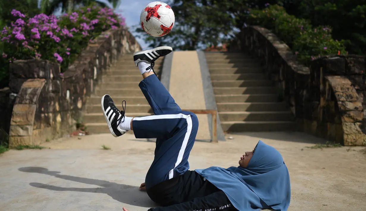 Aksi Qhouirunnisa Endang Wahyudi saat men-juggling bola di sebuah taman di Klang, Kuala Lumpur, (11/7). (AFP Photo/Mohd Rasfan)