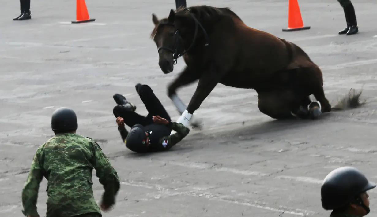 Seorang prajurit terlempar dari kudanya dalam parade militer di Zocalo, Mexico City, Rabu (20/11/2019). Parade militer tersebut untuk memperingati peringatan 109 tahun Revolusi Meksiko. (AP Photo/Marco Ugarte)