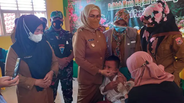 Wakil Bupati Bone Bolango (Bonebol) saat mendampingi siswa yang divaksinasi (Arfandi/Liputan6.com)