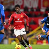 Gelandang Manchester United asal Inggris bernomor punggung 37, Kobbie Mainoo (C), berduel dengan gelandang Bournemouth asal Inggris bernomor punggung 16, Marcus Tavernier (L), selama pertandingan Liga Inggris antara Manchester United dan Bournemouth di Old Trafford, Manchester, barat laut Inggris, Selasa (16-12-2025) dini hari WIB. (PETER POWELL/AFP)