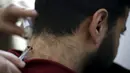 Pria Palestina, yang menderita masalah saraf di leher dan punggung, menerima terapi sengatan lebah di klinik Rateb Samour, Kota Gaza, 11 April 2016. Samour mengobati 250 pasien sehari, dengan keluhan dari rambut rontok hingga kanker (REUTERS/Suhaib Salem)
