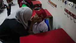 Seorang ibu mendampingi anaknya saat hari pertama masuk sekolah di SDN Pisangan 02, Ciputat, Tangerang Selatan, Senin (15/7/2019). Senin, 15 Juli 2019 merupakan hari pertama masuk sekolah tahun ajaran 2019/2020 usai libur panjang. (Liputan6.com/Faizal Fanani)