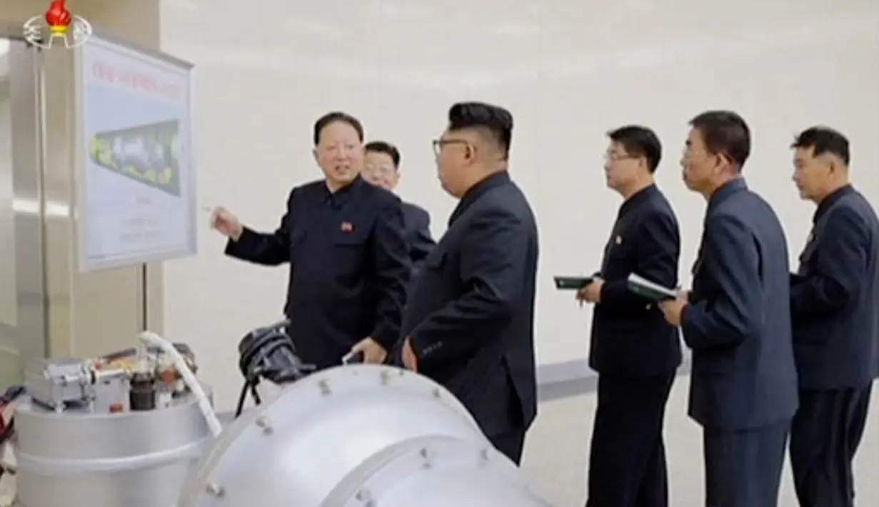 Kim Jong-un berbincang dengan para peneliti saat meninjau pembuatan bom hidrogen pada 3 September 2017. Bom ini diklaim berkekuatan hingga ratusan kiloton ini dibuat dengan berbagai komponen produksi dalam negeri. (KRT via AP Video)