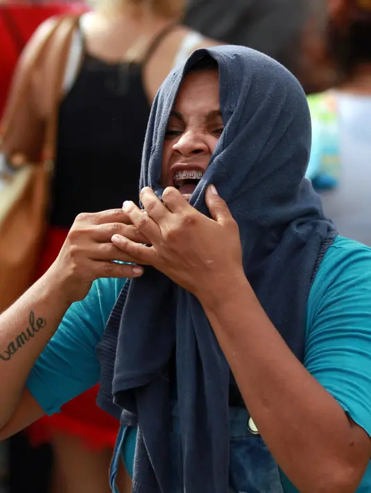 Seorang kerabat narapidana menangis di pos pemeriksaan menyusul kerusuhan yang terjadi di dalam penjara kota Amazon, Brasil, Senin (2/1). Insiden berdarah itu dipicu oleh perang antar gang obat bius yang ada di penjara tersebut. (REUTERS/Michael Dantas)