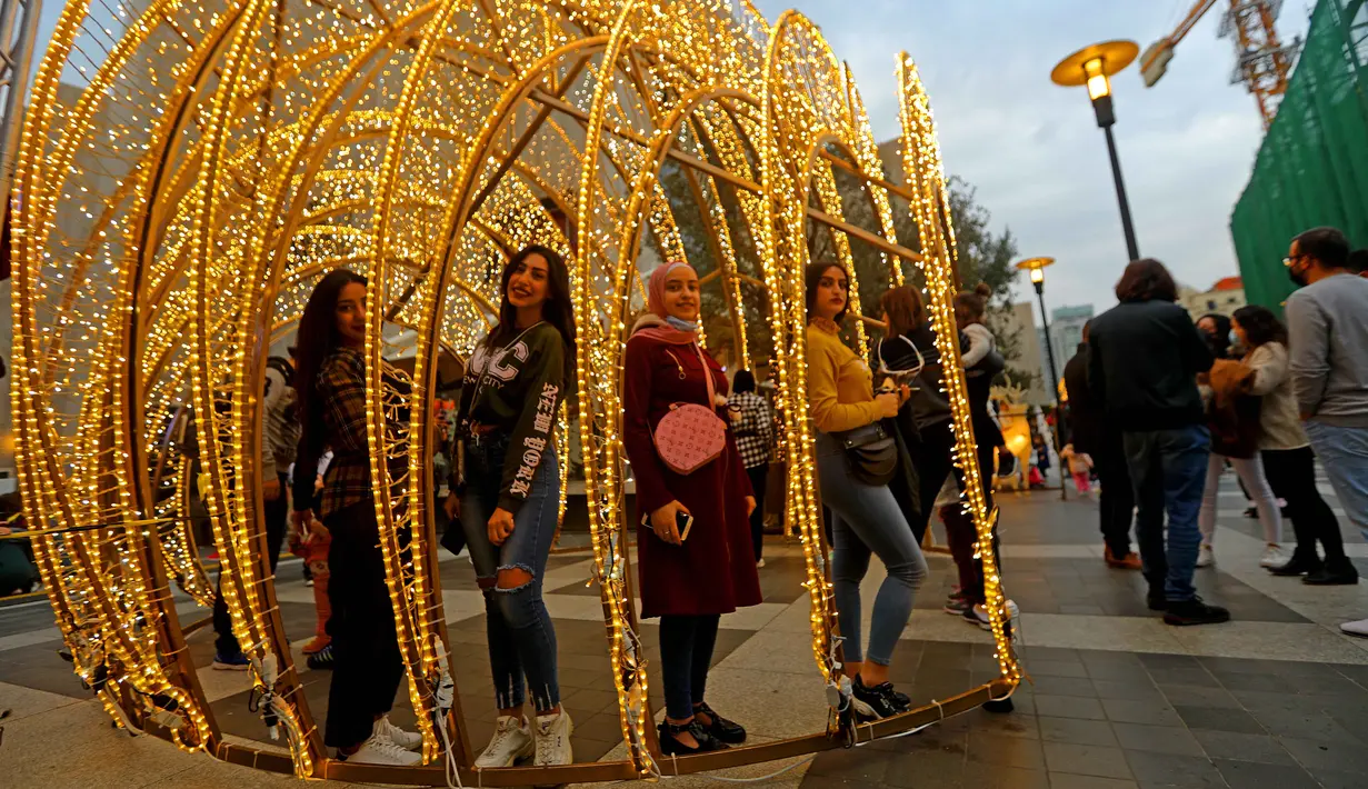 Sejumlah anak perempuan berpose dengan instalasi cahaya Natal di pusat kota Beirut, Lebanon, pada 13 Desember 2020. Baru-baru ini, berbagai dekorasi Natal telah dipasang di pusat kota Beirut menyambut liburan Natal dan Tahun Baru mendatang meski sedang dilanda pandemi COVID-19. (Xinhua/Bilal Jawich)