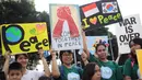 Warga menunjukkan poster saat melakukan kampanye tentang perdamaian dunia saat car free day di kawasan Bunderan HI, Jakarta, Minggu (27/5). Kampanye tersebut bertujuan sebagai seruan untuk menghentikan peperangan. (Liputan6.com/Faizal Fanani)