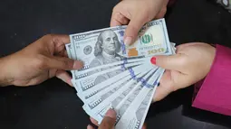 Karyawan menunjukkan lembaran uang Dolar AS di VIP Money Changer, Jakarta, Jumat (5/6/2026). (merdeka.com/Arie Basuki)