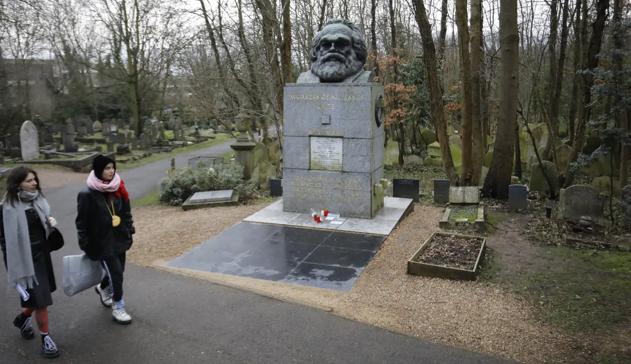 Pengunjung berjalan dekat makam filsuf ternama Jerman dan tokoh sosialisme, Karl Marx, di Pemakaman Highgate, London, Selasa (5/2). Nisan peringatan terbuat dari marmer yang menandakan persemayaman Marx dirusak oleh orang tidak dikenal. (Tolga AKMEN/AFP)