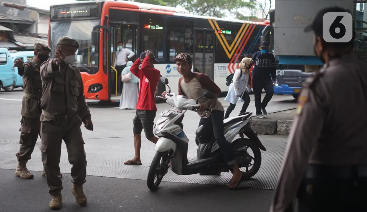 Petugas memberhentikan warga pelanggar Operasi Yustisi Pencegahan Covid-19 di kawasan Kampung Melayu, Jakarta Timur, Senin (16/11/2020). Operasi tersebut digelar guna menyadarkan masyarakat akan pentingnya penggunaan masker di tengah pandemi Covid-19. (Liputan6.com/Immanuel Antonius)