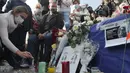 Seorang wanita menyalakan lilin di alun-alun Republique selama demonstrasi di Paris (18/10/2020). Samuel Paty dipenggal pada hari Jumat di Conflans-Sainte-Honorine oleh seorang pengungsi Chechnya. (AP Photo/Michel Euler)