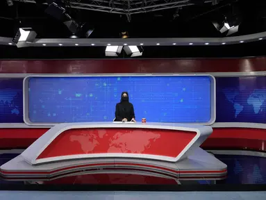 Khatereh Ahmadi, seorang presenter televisi mengenakan penutup wajah saat membacakan berita di TOLO NEWS, di Kabul, Afghanistan, Minggu, 22 Mei 2022. Taliban mulai mewajibkan semua presenter atau pembawa acara televisi perempuan menutupi wajah mereka saat siaran. (AP Photo/Ebrahim Noroozi)