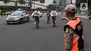 Satpol PP menegur pesepeda yang tidak mengenakan masker dengan benar saat melintas di kawasan Bundaran HI, Jakarta, Minggu (17/1/2021). Sosialisasi penggunaan masker untuk mencegah penularan virus corona COVID-19 masih saja diabaikan karena rendahnya kesadaran masyarakat. (Liputan6.com/Johan Tallo)