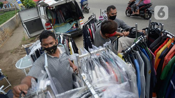 Ridwan (40) menata baju seken (baju bekas) impor di Pamulang, Tangerang Selatan, Banten, Senin (29/9/2020). Sebelumnya Ridwan merupakan pengusaha alat sewa pesta, karena kondisi pandemi Covid-19 sepi hajatan iya beralih menjual baju bekas demi memenuhi kebutuhan sehari-hari. (merdeka.com/Dwi Narwoko