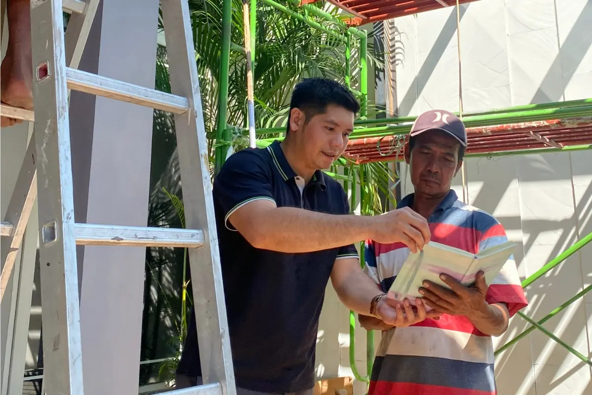 Rio (kiri) saat menggarap proyek pemasangan kanopi di Surabaya. (Istimewa)