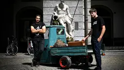 Dua orang pria berdiri dekata Ape saat pameran memperingati 70 tahun Ape di Aosta, Italia utara (1/7). Dalam acara ini pemilik dan kolektor Piaggio Ape berkumpul untuk merayakan ulang tahun Ape yang ke-70. (AFP Photo/Marco Bertorello)