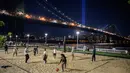 Orang-orang bermain bola voli di tepi pantai Brooklyn sebelum instalasi 'Tribute in Light' memperingati serangan teroris 9/11, di New York (10/9/2021). (AFP/Ed Jones)