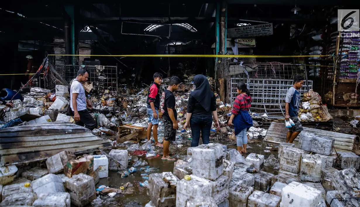Sejumlah pedagang mengamati ruko mereka yang terbakar di Pasar Induk Kramat Jati Blok C1, Jakarta Timur, Senin (12/6). Akibat kebakaran yang terjadi sekitar 02.05 WIB itu, kurang lebih 90 kios bumbu dapur hangus terbakar. (Liputan6.com/Faizal Fanani)
