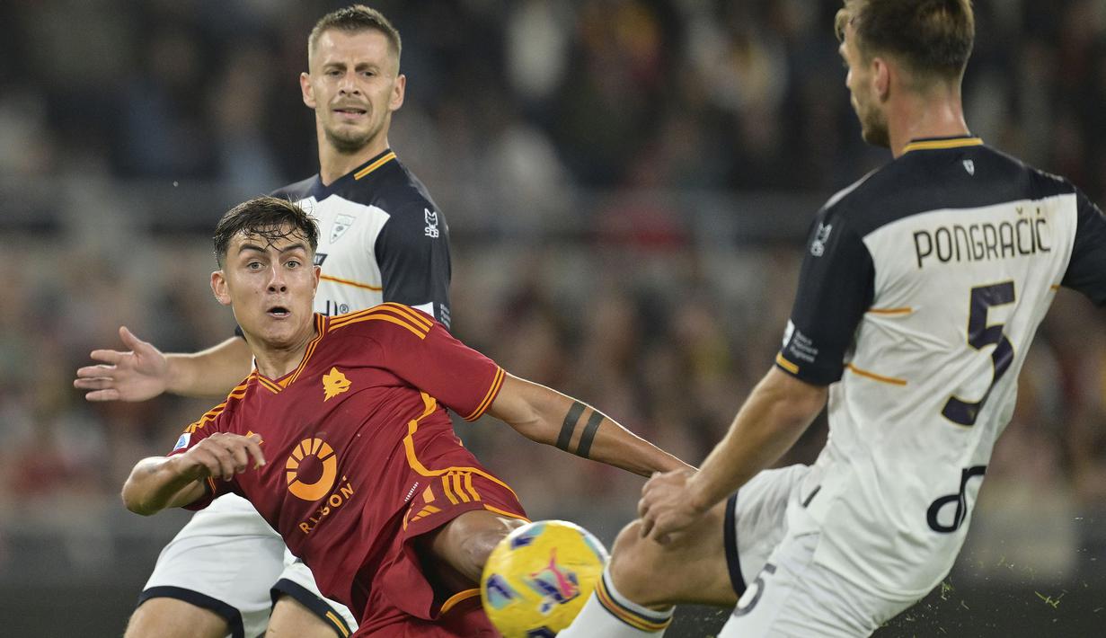 Striker AS Roma, Paulo Dybala (tengah) melepaskan tendangan di antara dua pemain Lecce pada laga pekan ke-11 Liga Italia 2023/2024 di Olimpico Stadium, Roma, Senin (6/11/2023) dini hari WIB. (LaPresse via AP Photo/Alfredo Falcone)