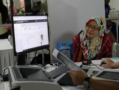 Petugas melayani pembuatan paspor salah satu warga saat berlangsungnya Immigration Servis pada hari bebas kendaraan bermotor di kawasan Plaza Parkir Timur Gelora Bung Karno, Jakarta, Minggu (28/1/2024). (Liputan6.com/Herman Zakharia)