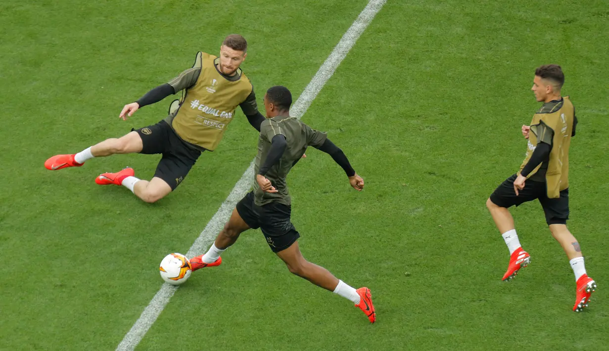 Pemain Arsenal, Joe Willock (tengah) menggiring bola melewati Shkodran Mustafi (kiri) disaksikan Lucas Torreira (kanan) berlatih jelang menghadapi Chelsea dalam final Liga Europa 2018/2019 di Olympic Stadium, Baku, Azerbaijan, Sealasa (28/5/2019). (AP Photo/Dmitri Lovetsky)