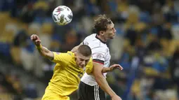 Bek Ukraina, Vitaliy Mykolenko berebut bola udara dengan gelandang Jerman, Leon Goretzka pada pertandingan  UEFA Nations League di Stadion Olimpiyskiy di Kyiv, Ukraina, Sabtu (10/10/2020). Jerman menang 2-1 atas Ukraina. (AP Photo/Efrem Lukatsky)