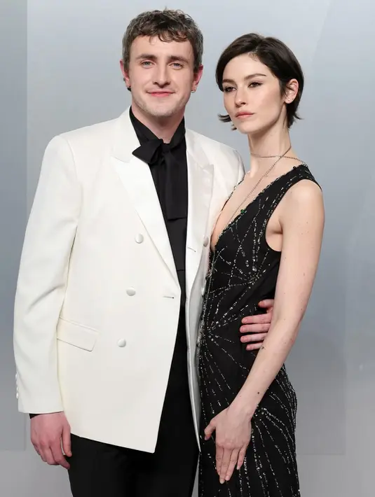 Paul Mescal dan Gracie Abrams memilih pendekatan yang lebih understated namun tetap stylish. Paul tampil dalam setelan hitam dari Celine yang klasik, sementara Gracie mengenakan kombinasi velvet hitam dan rok bertekstur emas dari Chanel. Minimal effort, maximum impact.