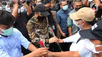 Mantan wakil ketua KPK Bambang Widjojanto memberikan bunga ke Novel Baswedan di luar Gedung KPK, Jakarta, Kamis (30/9/2021). 57 + 1 pegawai KPK yang tak lolos TWK untuk alih status ASN diberhentikan dengan hormat per 30 September 2021. (Liputan6.com/Herman Zakharia)