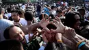 Petugas kemananan setempat dibantu warga menangani pria yang kesurupan saat mengikuti festival tato suci di Biara Wat Bang Phra, Nakhon Pathom, Thailand (3/3). (AFP Photo/Lillian Suwanrumpha)
