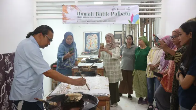 Budi Harry menunjukkan teknik melukis motif batik menggunakan malam.