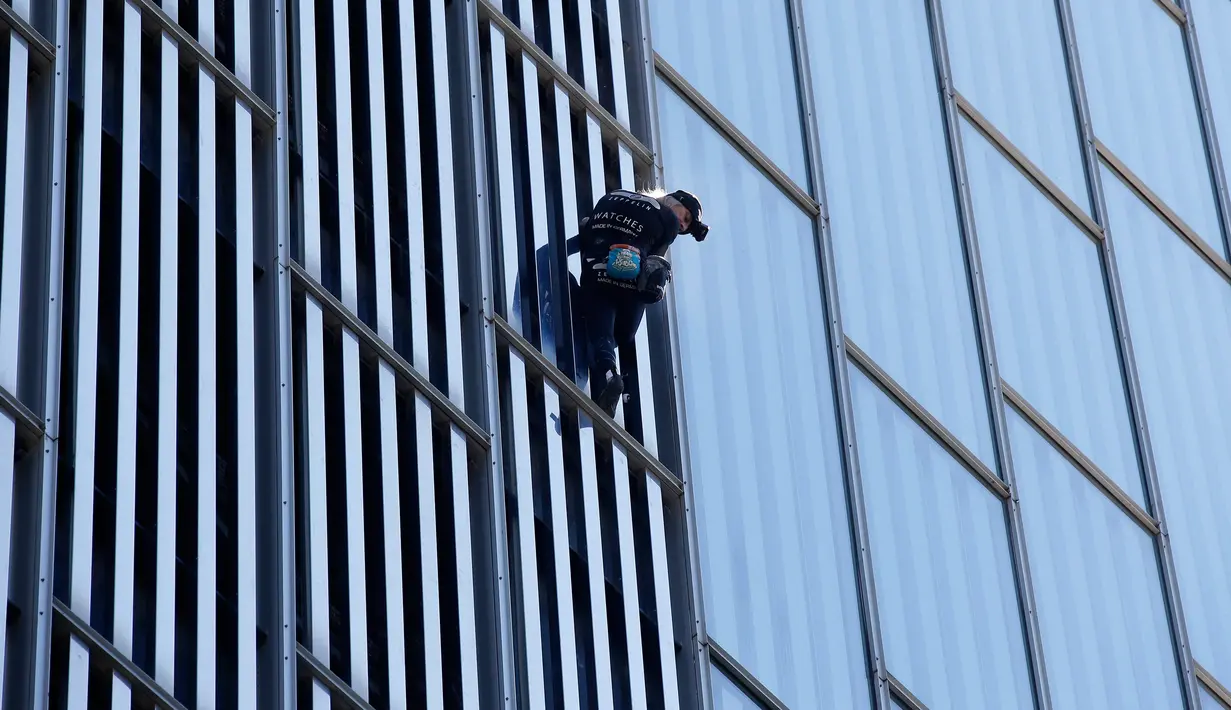 Pemanjat asal Prancis Alain Robert, melihat ke bawah saat memanjat Melia Barcelona Sky Hotel di Spanyol, Senin (12/6). Pria 54 tahun itu menunjukkan aksinya dengan menaklukkan gedung setinggi 116 meter tanpa pengaman. (AP Photo/Manu Fernandez)