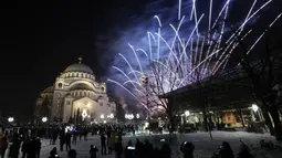 Kembang api menerangi langit di atas Kuil St. Sava di Beograd, Serbia, Jumat (14/1/2022). Umat Kristen Ortodoks di Serbia merayakan Tahun Baru pada 14 Januari, menurut kalender Julian. (AP Photo/Darko Vojinovic)