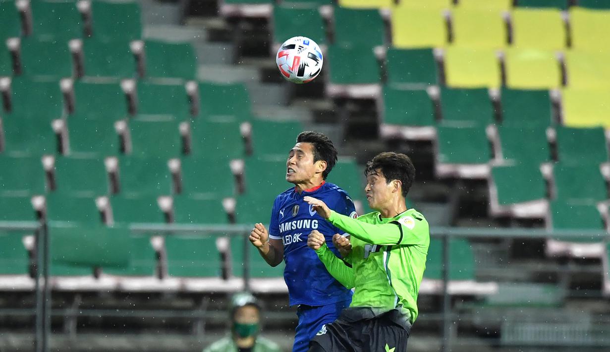 Pemain Jeonbuk Hyundai Motors berebut bola dengan pemain Suwon Samsung Blue Wings pada laga K-League Korea Selatan di Jeonju World Cup Stadium, Jeonju, Jumat (8/5/2020). Jeonbuk Hyundai Motors menang 1-0 atas Suwon Samsung Blue Wings.(AFP/Jung Yeon-Je)