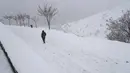 Seorang pria berjalan turun di Kompleks Olahraga dan Rekreasi Tochal yang bergunung-gunung saat salju turun, di utara Teheran, Iran (24/12/2022). Salju dan hujan membawa kebahagiaan bagi banyak orang yang khawatir kekurangan air di Iran, negara yang telah mengalami kekeringan selama beberapa dekade. (AP Photo/Vahid Salemi)