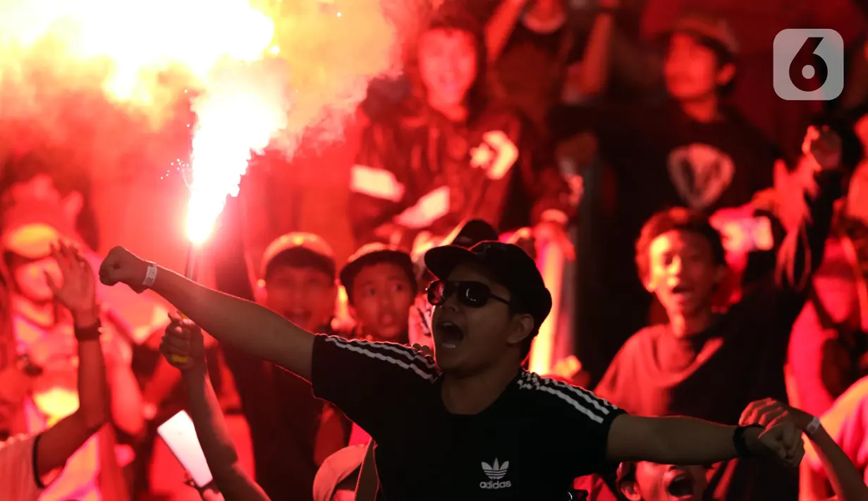 Suporter Persija menyalakan suar saat merayakan HUT ke-91 Persija dan kemenangan atas Persipura di laga lanjutan Shopee Liga 1 Indonesia 2019 di Stadion Utama Gelora Bung Karno, Jakarta, Kamis (28/11/2019). Persija unggul 1-0. (Liputan6.com/Helmi Fithriansyah)