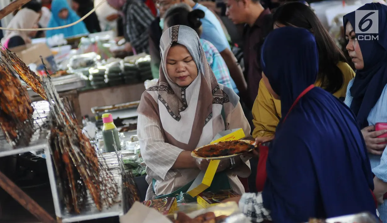 Pedagang melayani pembeli yang mencari makanan dan minumam untuk berbuka puasa atau takjil di kawasan Bendungan Hilir atau Benhil, Jakarta, Senin (6/5/2019). Kawasan Benhil menjadi tempat warga dan pekerja kantoran untuk berburu menu takjil setiap Ramadan. (Liputan6.com/Herman Zakharia)