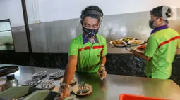 Pramusaji lengkap dengan APD berupa face shield, sarung tangan dan masker menyiapkan alat makan di Restoran Bandar Djakarta, Alam Sutera, Tangerang Selatan, Rabu (10/6/2020). Meski PSBB Tangerang Raya diperpanjang restoran tetap menerapkan protokol kesehatan. (Liputan6.com/Fery Pradolo)